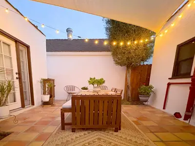 a patio with a table and chairs and lights at Casita Gundry- Boutique Hideaway, Quaint Historic Charm in Long Beach