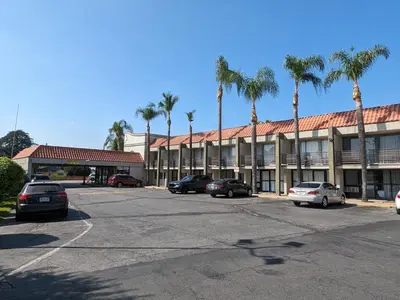 a building with cars parked in a parking lot at Valley Inn in Mission Hills