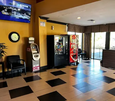 a lobby with a soda machine and a television at Valley Inn in Mission Hills