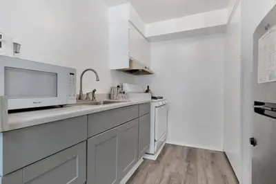 a white kitchen with a sink and a microwave at Magic Castle Hotel in Los Angeles