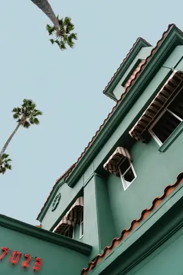 a green building with two palm trees on top of it at Palihotel Hollywood near Universal Studios in Los Angeles