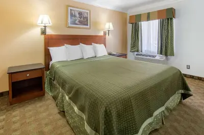 a hotel room with a large bed and a window at Rodeway Inn Adelanto US 395 in Adelanto