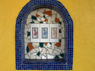 a mosaic window on a wall with blue tiles at Sandyland Reef Inn in Carpinteria
