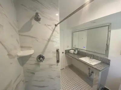 a white bathroom with a sink and a mirror at Ocean Lodge Santa Monica Beach Hotel in Los Angeles