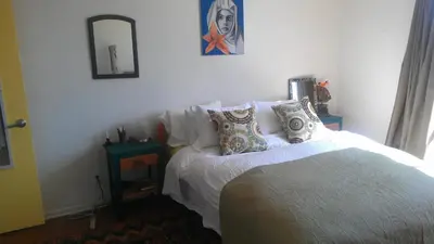 a bedroom with a bed with pillows and a mirror at Ocean Front Vortex Female Hostel private rooms Free bikes in Los Angeles