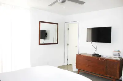 a bedroom with a bed and a television on a dresser at Ocean Front Vortex Female Hostel private rooms Free bikes in Los Angeles
