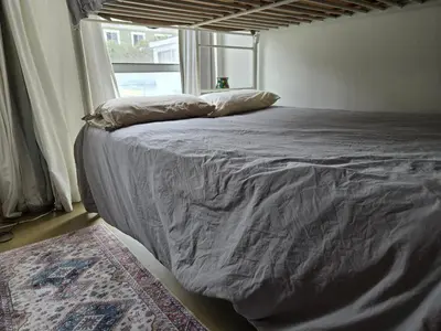 a large bed in a room with a window at Ocean Front Vortex Female Hostel private rooms Free bikes in Los Angeles