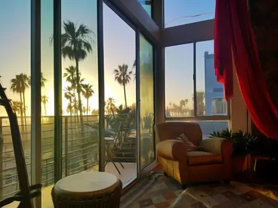 a living room with a chair and large windows at Ocean Front Vortex Female Hostel private rooms Free bikes in Los Angeles