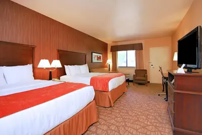 a hotel room with two beds and a flat screen tv at Best Western San Dimas Hotel & Suites in San Dimas