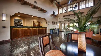 a restaurant with a bar and a table and chairs at Best Western San Dimas Hotel & Suites in San Dimas