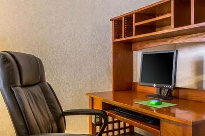 a desk with a computer monitor and a chair at Quality Inn Barstow Route 66 in Barstow