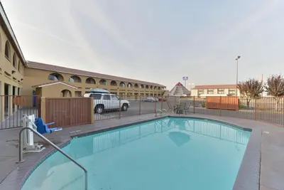 a large swimming pool in front of a building at Rodeway Inn Delano in Delano
