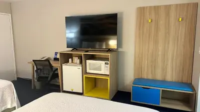 a room with a microwave and a television on a shelf at Days Inn by Wyndham Ridgecrest near China Lake Naval Station in Ridgecrest