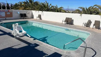 a large swimming pool with a chair at Days Inn by Wyndham Ridgecrest near China Lake Naval Station in Ridgecrest