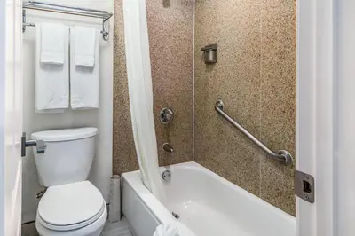 a bathroom with a toilet and a tub and a sink at Inn at 50 Long Beach Convention Center in Long Beach