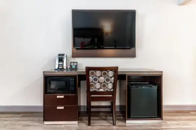 a desk with a chair and a tv on a wall at Inn at 50 Long Beach Convention Center in Long Beach