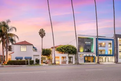 a building on a street with palm trees at Comfort Inn Santa Monica - West Los Angeles in Los Angeles