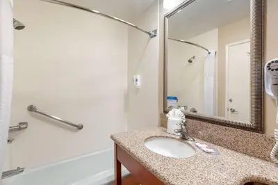 a bathroom with a sink and a tub and a mirror at Comfort Inn Santa Monica - West Los Angeles in Los Angeles