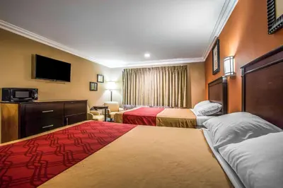 a hotel room with two beds and a television at Baymont by Wyndham Ontario in Ontario
