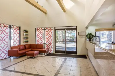 a living room with a leather couch and glass doors at Rodeway Inn Magic Mountain Area in Castaic