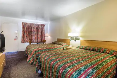 a hotel room with two beds and a television at Rodeway Inn Magic Mountain Area in Castaic