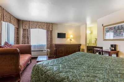 a hotel room with a bed and a couch at Rodeway Inn Magic Mountain Area in Castaic