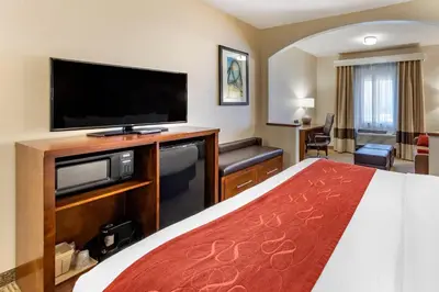 a hotel room with a bed and a flat screen tv at Comfort Suites Near Six Flags Magic Mountain in Stevenson Ranch