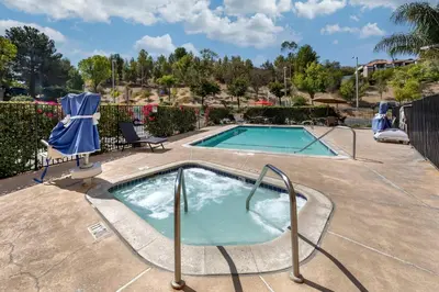 a pool with a hot tub in a yard at Comfort Suites Near Six Flags Magic Mountain in Stevenson Ranch