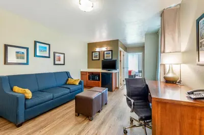 a living room with a blue couch and a desk at Comfort Inn & Suites Lancaster Antelope Valley in Lancaster