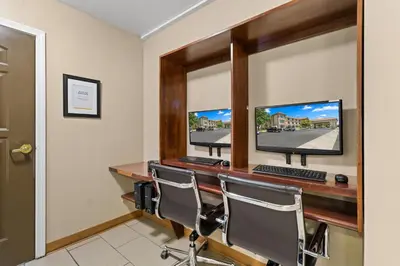 a room with two computer monitors on a desk at Comfort Inn & Suites Lancaster Antelope Valley in Lancaster