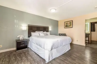 a bedroom with a large white bed and a table at Rodeway Inn Barstow Route 66 in Barstow