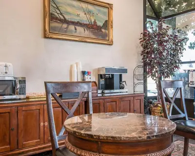 a kitchen with a table and two chairs and a coffee maker at Palm Inn Hotel near Tyler Mall Riverside in Riverside