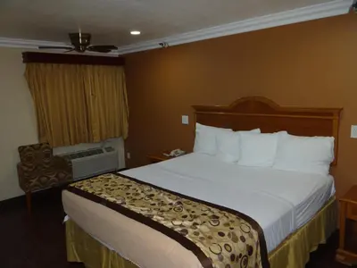 a hotel room with a bed and a chair at Rodeway Inn Cypress - Buena Park in Cypress