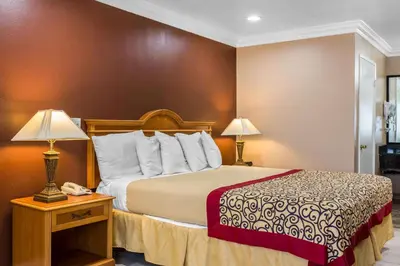 a hotel room with a bed and a telephone at Rodeway Inn Cypress - Buena Park in Cypress