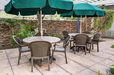 a group of tables and chairs with umbrellas at Tilt Hotel Universal-Hollywood, an AGA Collection Hotel in Los Angeles