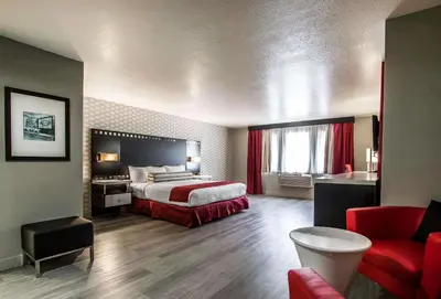 a hotel room with a bed and a red couch at Tilt Hotel Universal-Hollywood, an AGA Collection Hotel in Los Angeles