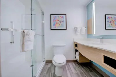 a bathroom with a toilet and a glass shower at Hilton Garden Inn Anaheim/Garden Grove in Anaheim