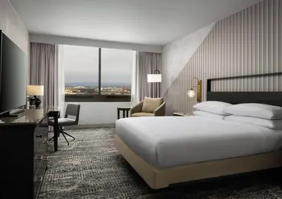 a hotel room with a bed and a desk and chairs at Hotel Fera Anaheim, a DoubleTree by Hilton Hotel in Anaheim