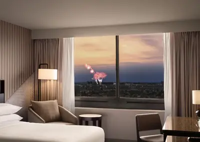 a room with a bed and a window with a fireworks display at Hotel Fera Anaheim, a DoubleTree by Hilton Hotel in Anaheim