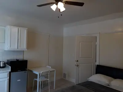 a kitchen with a ceiling fan and a table and a bed at Pads on Pasadena Ave in Los Angeles