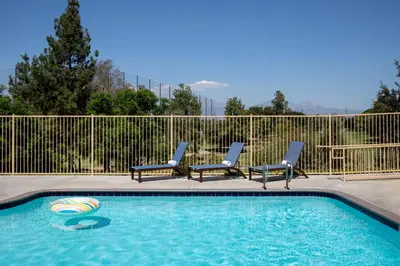 a swimming pool with two lounge chairs and a swimming pool at Ayres Suites Diamond Bar in Diamond Bar