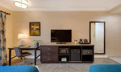 a hotel room with a desk and a television at Ayres Suites Diamond Bar in Diamond Bar