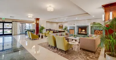 a lobby with couches and chairs and a fireplace at Ayres Hotel Corona - Riverside in Corona