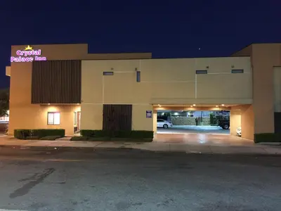 a large building with a parking garage at night at Crystal Palace Inn in Maywood