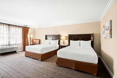 a hotel room with two beds and a desk at Best Western Ontario Mills Mall in Ontario
