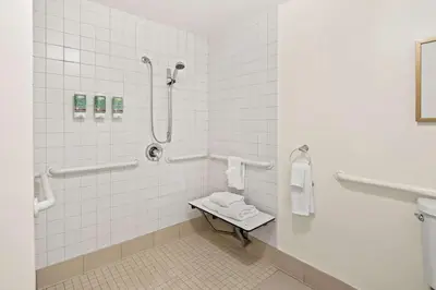 a white bathroom with a shower and a sink at Best Western Ontario Mills Mall in Ontario