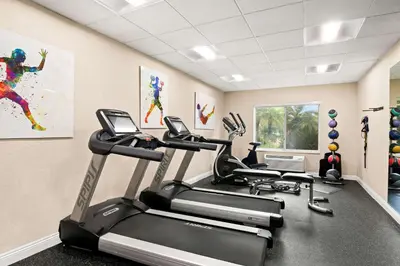 a gym with three tread machines in a room at Best Western Ontario Mills Mall in Ontario