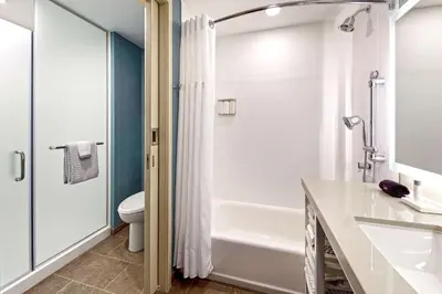 a bathroom with a tub and a toilet and a sink at Anaheim Resort Suites in Anaheim