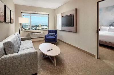 a living room with a couch and a table and a bed at Anaheim Resort Suites in Anaheim