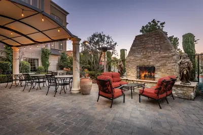 a patio with chairs and a stone fireplace at Ayres Hotel Seal Beach - Cypress in Seal Beach